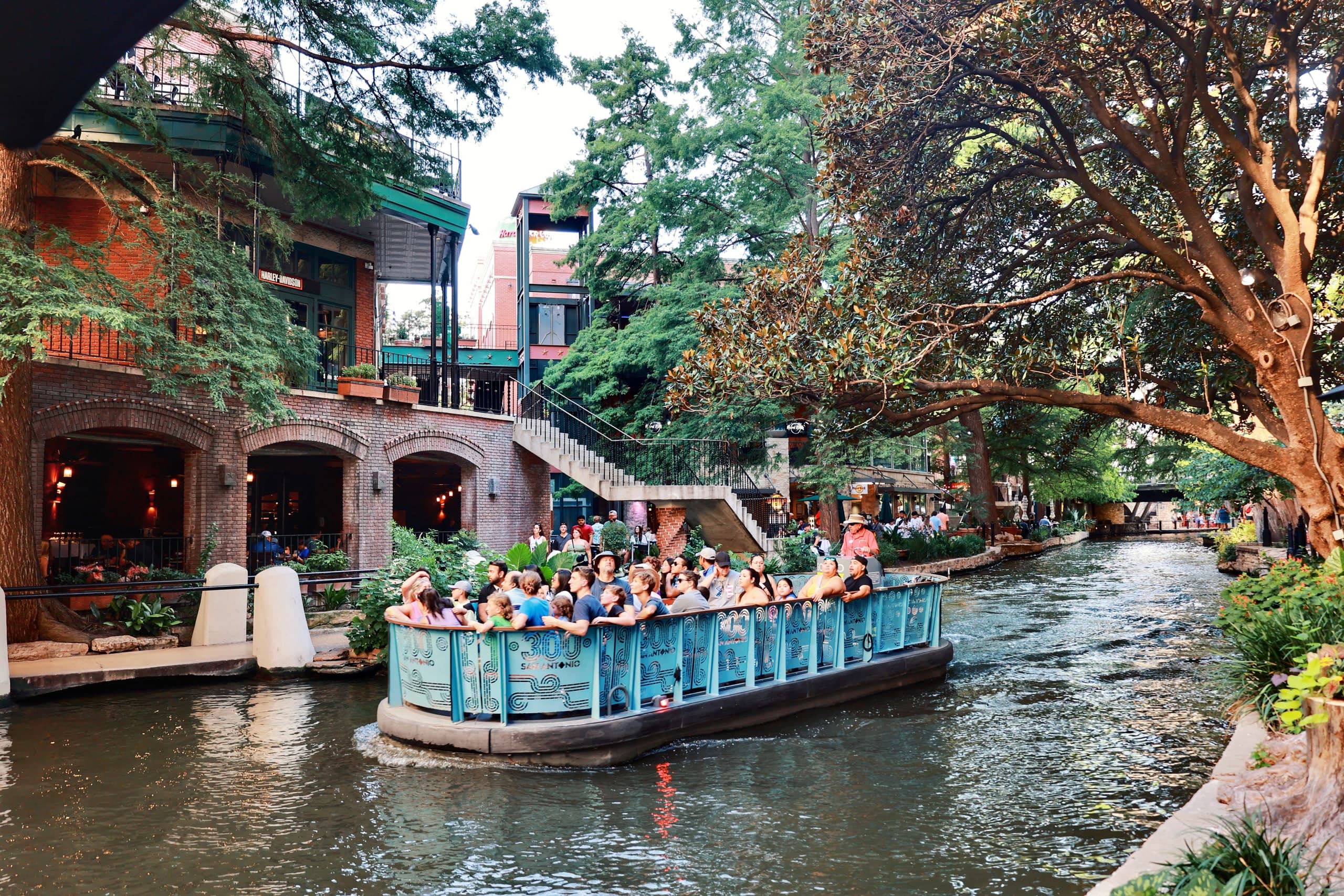 Visitors aboard a barge on the San Antonio River Walk