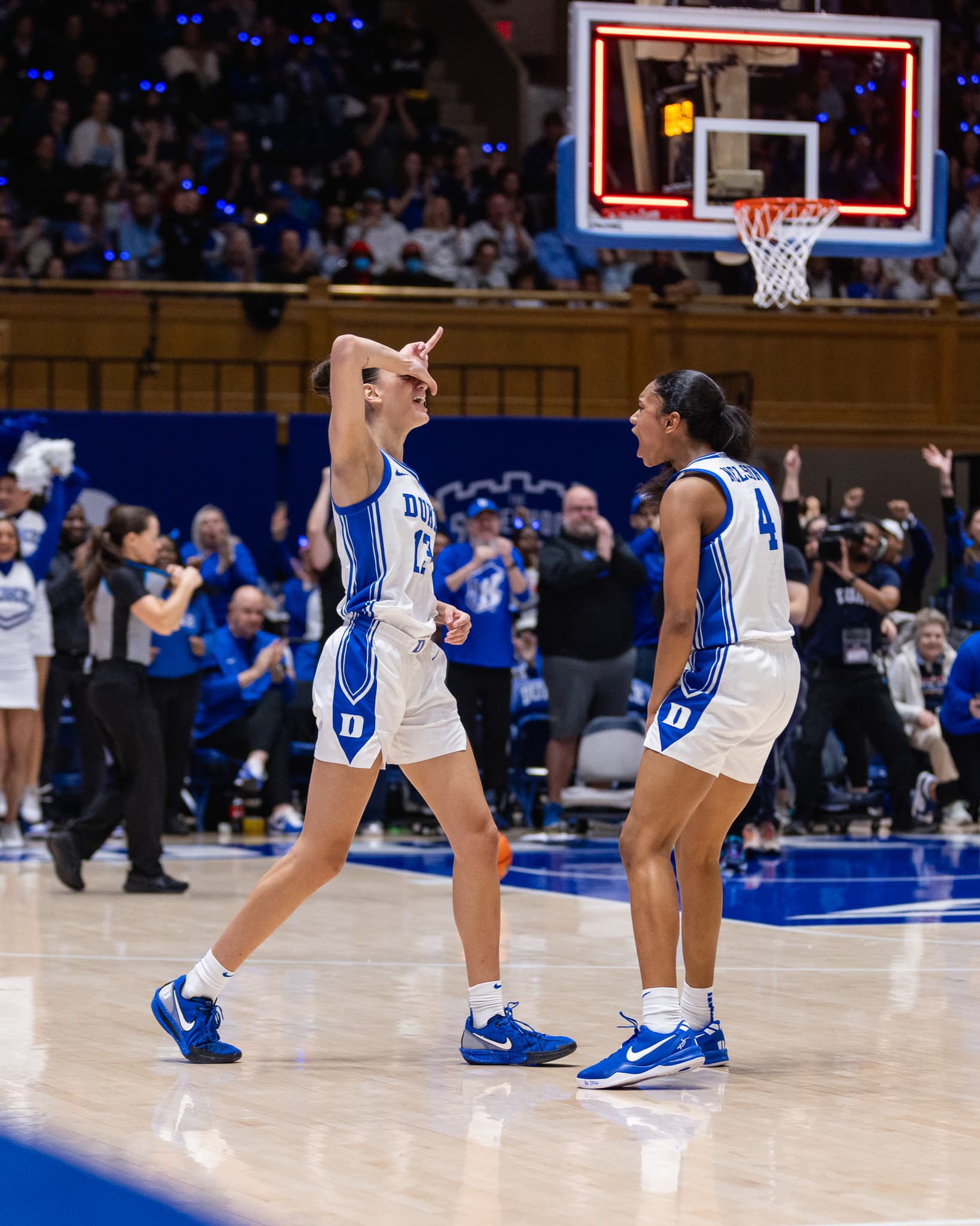 Two Duke players facing each other mid-celebration on court