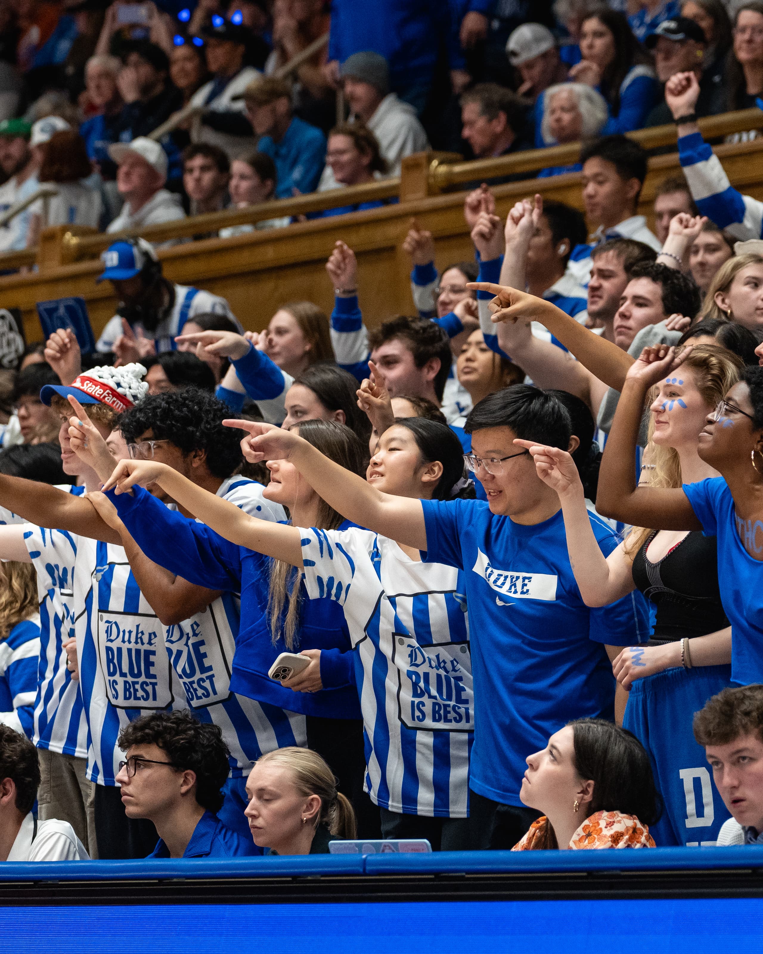 Duke students in the front row pointing toward the court