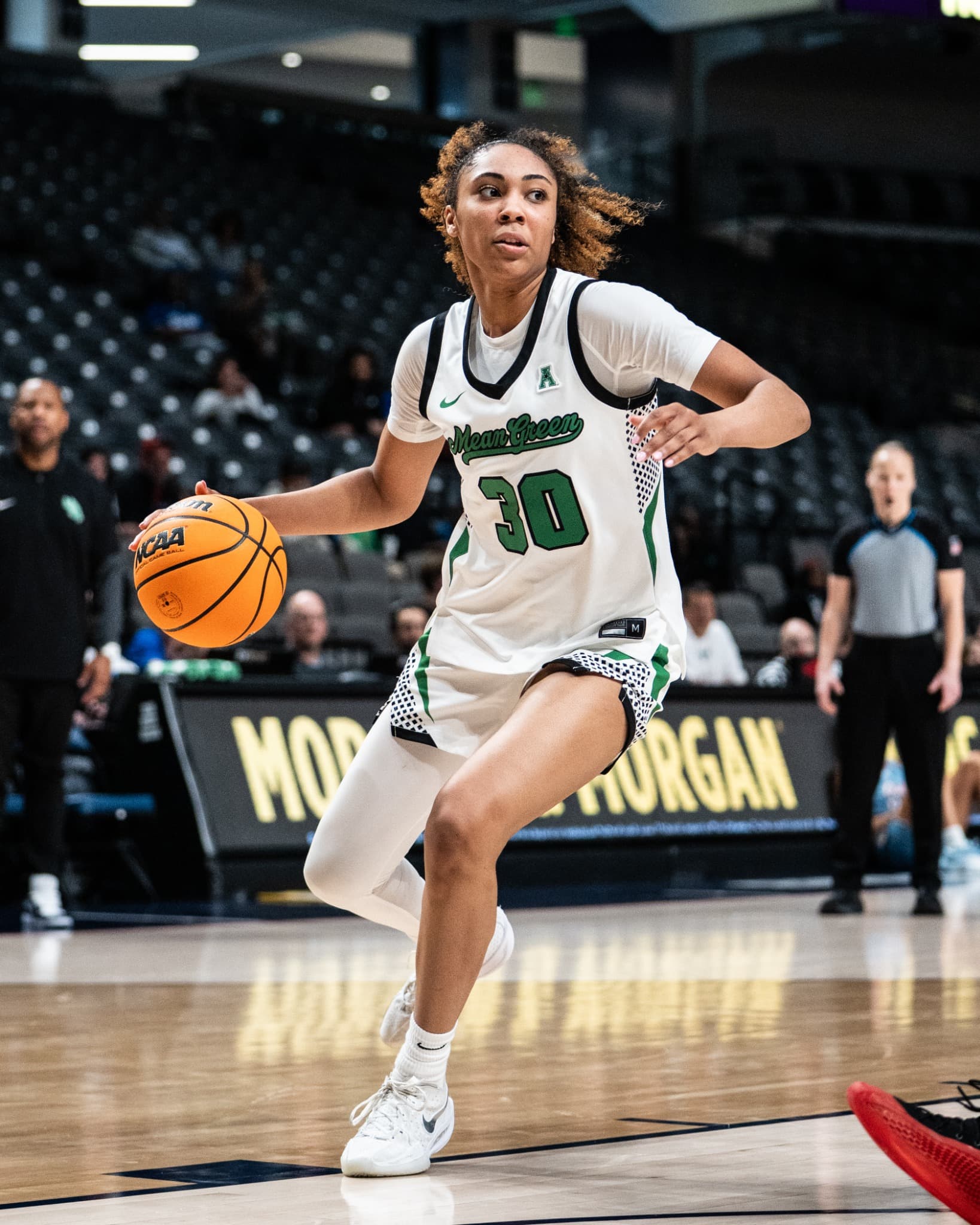 A North Texas player driving the ball up court